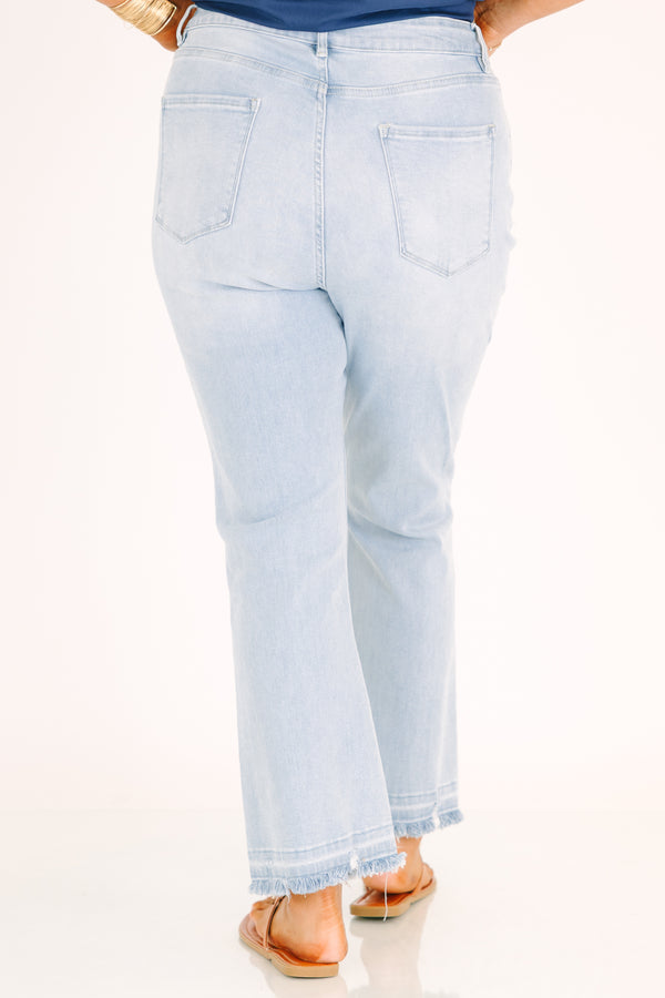 Plus Size light wash flare jeans with a high-rise fit and frayed raw hems.
