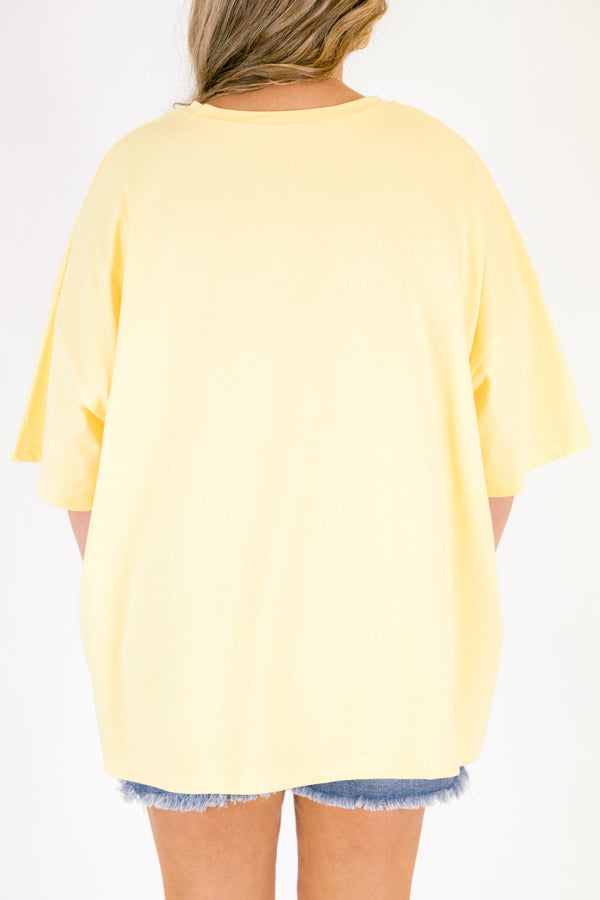 Chic Soul plus size clothing, butter yellow short sleeve oversized tee with “island girl” text in script font with a flower off to the side