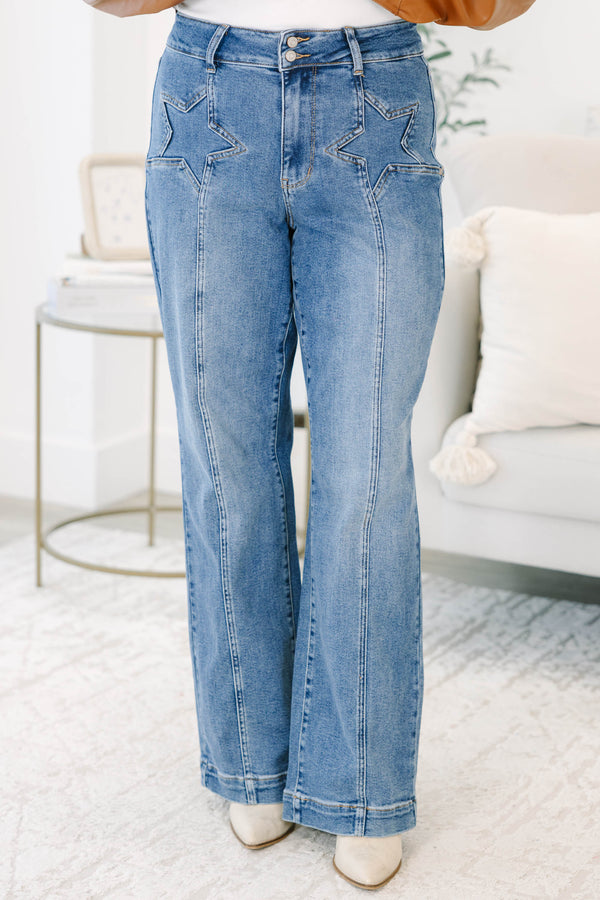 Plus Size medium wash wide leg jeans with star-shaped stitching on the front pockets and seams.