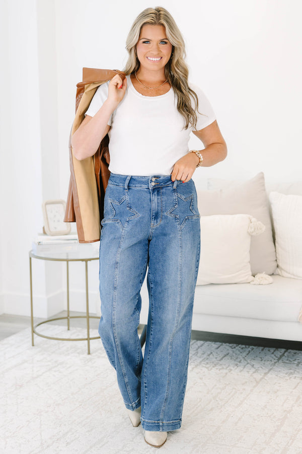 Plus Size medium wash wide leg jeans with star-shaped stitching on the front pockets and seams.