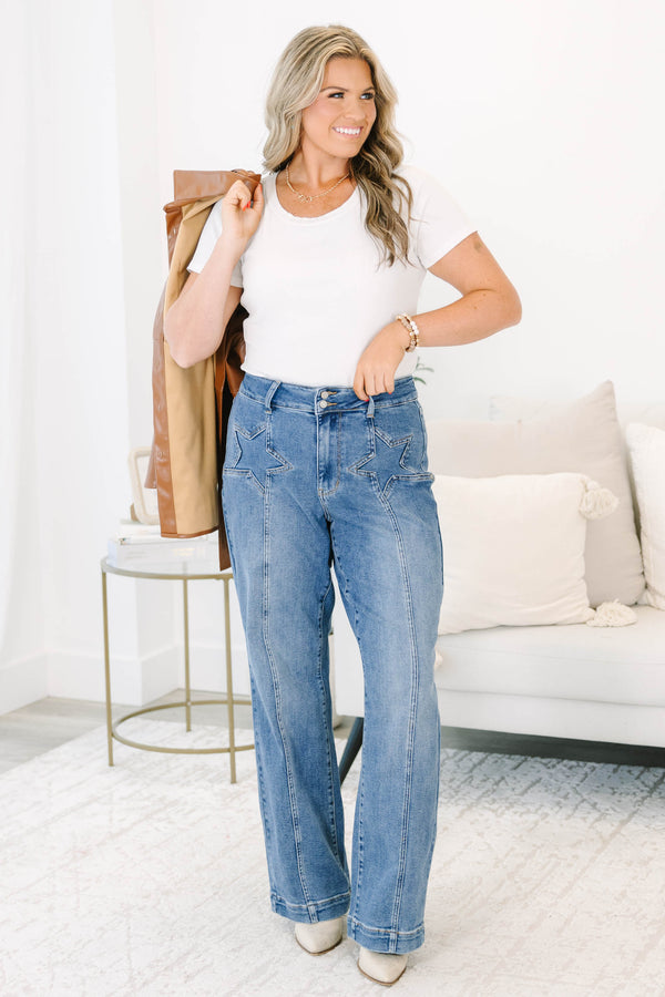 Plus Size medium wash wide leg jeans with star-shaped stitching on the front pockets and seams.