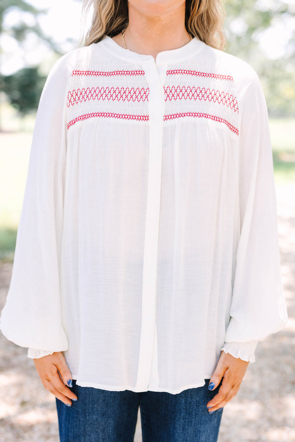 Plus Size cream long-sleeved top with red smocked embroidery on the chest and smocked cuffs.