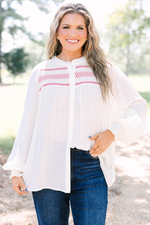 Plus Size cream long-sleeved top with red smocked embroidery on the chest and smocked cuffs.