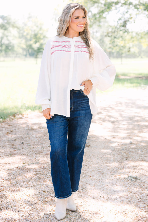 Plus Size cream long-sleeved top with red smocked embroidery on the chest and smocked cuffs.