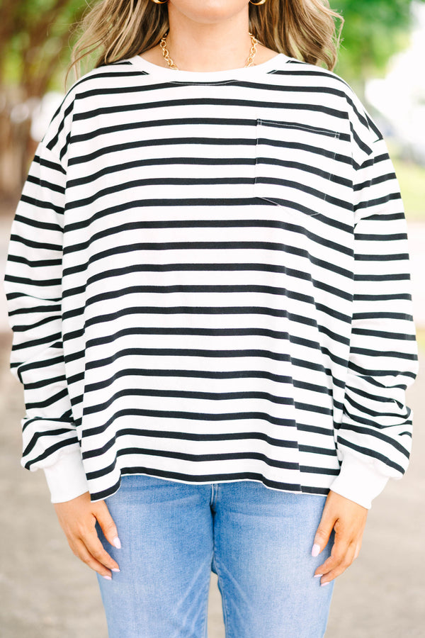 Plus size woman in a flowy white and black striped long sleeve cotton top with a front pocket.
