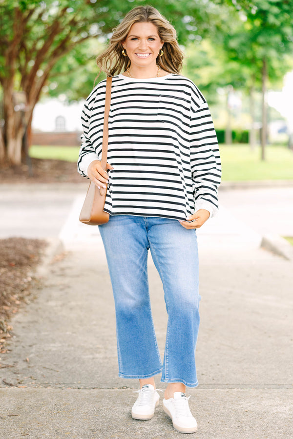 Plus size woman in a flowy white and black striped long sleeve cotton top with a front pocket.