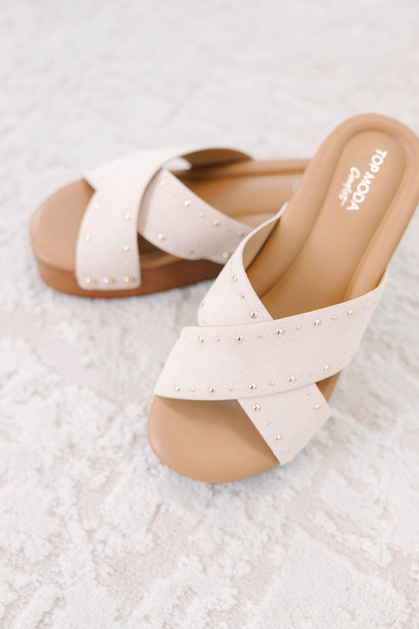Plus Size beige platform wedge sandals with crisscross suede straps and gold stud embellishments.