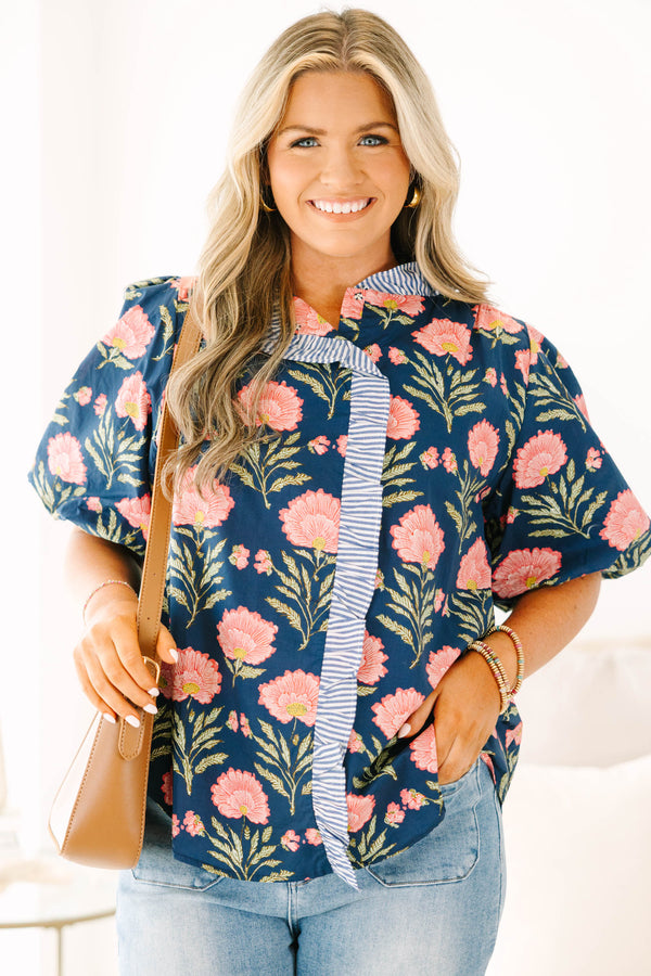 Navy floral top with elastic puff sleeves and blue and white striped ruffle trim.