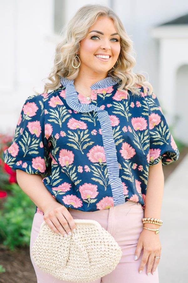 Navy floral top with elastic puff sleeves and blue and white striped ruffle trim.