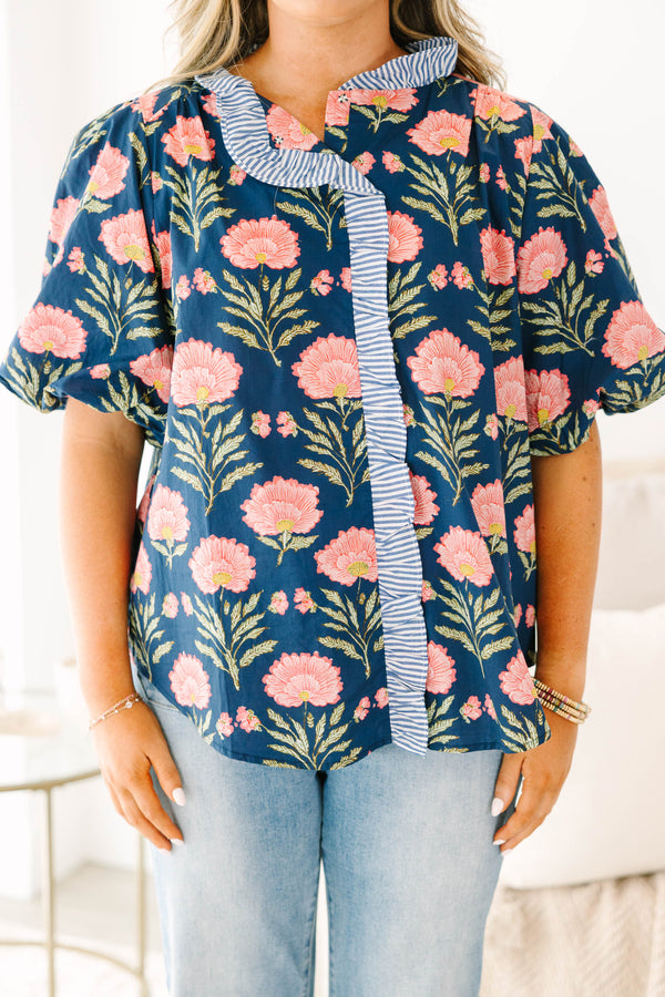 Navy floral top with elastic puff sleeves and blue and white striped ruffle trim.