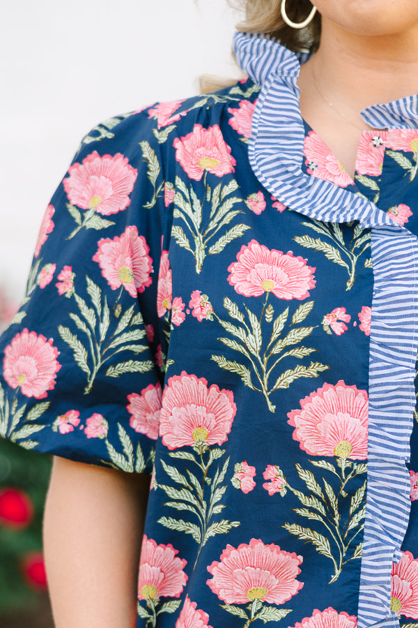 Navy floral top with elastic puff sleeves and blue and white striped ruffle trim.