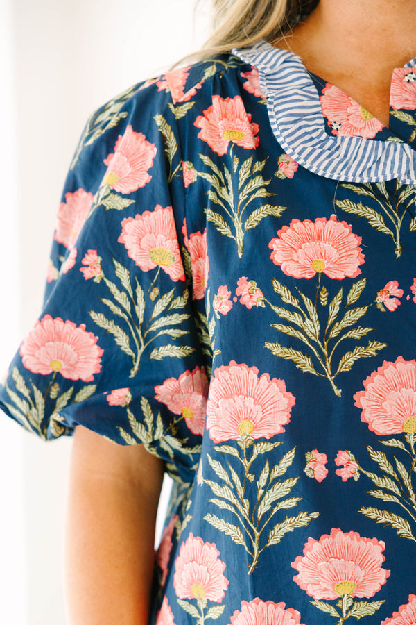 Navy floral top with elastic puff sleeves and blue and white striped ruffle trim.