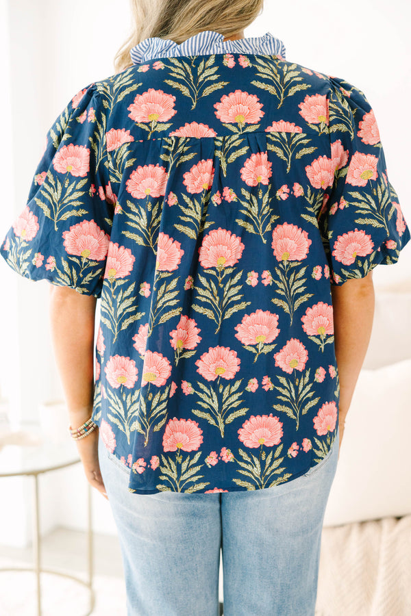 Navy floral top with elastic puff sleeves and blue and white striped ruffle trim.