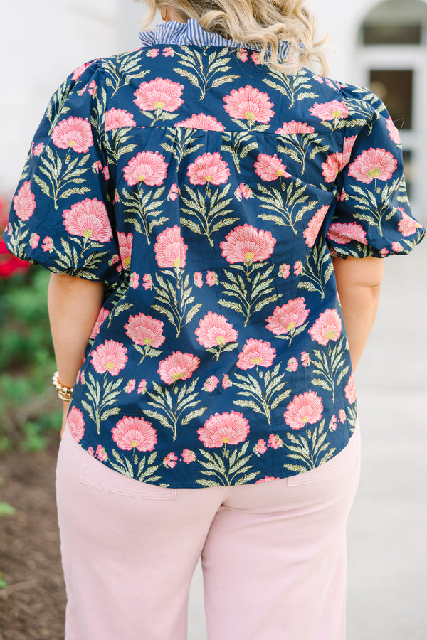 Navy floral top with elastic puff sleeves and blue and white striped ruffle trim.