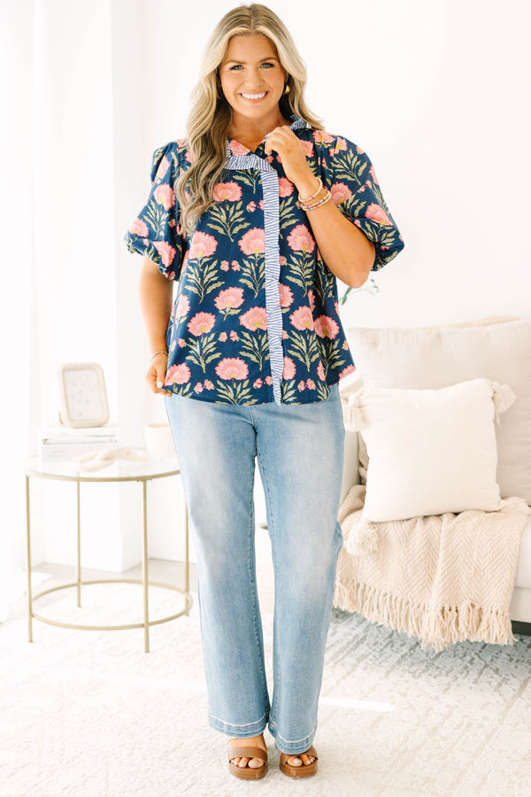 Navy floral top with elastic puff sleeves and blue and white striped ruffle trim.