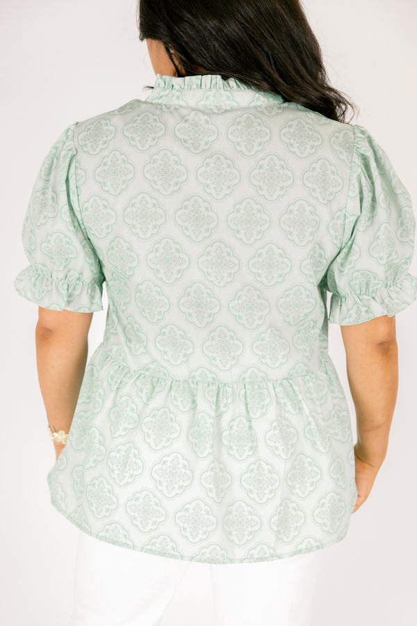 Chic Soul plus size clothing, green top with bubble sleeves that have a ruffle detail at the end of each sleeve as week as a ruffle detail on the collar a slight v-neckline and block abstract pattern throughout  

