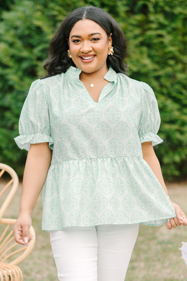 Chic Soul plus size clothing, green top with bubble sleeves that have a ruffle detail at the end of each sleeve as week as a ruffle detail on the collar a slight v-neckline and block abstract pattern throughout  