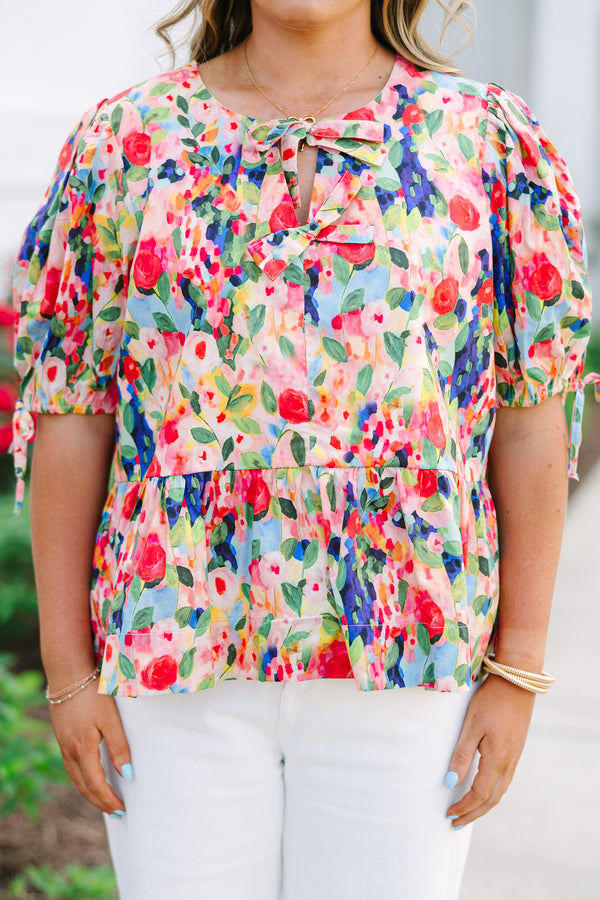 Plus size pink floral watercolor peplum top with puff sleeves and a bow neckline detail.