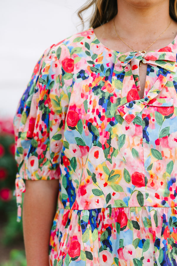 Plus size pink floral watercolor peplum top with puff sleeves and a bow neckline detail.