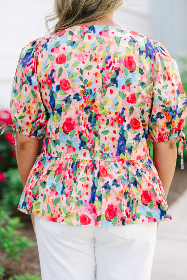 Plus size pink floral watercolor peplum top with puff sleeves and a bow neckline detail.