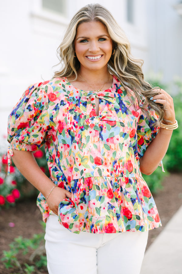 Plus size pink floral watercolor peplum top with puff sleeves and a bow neckline detail.