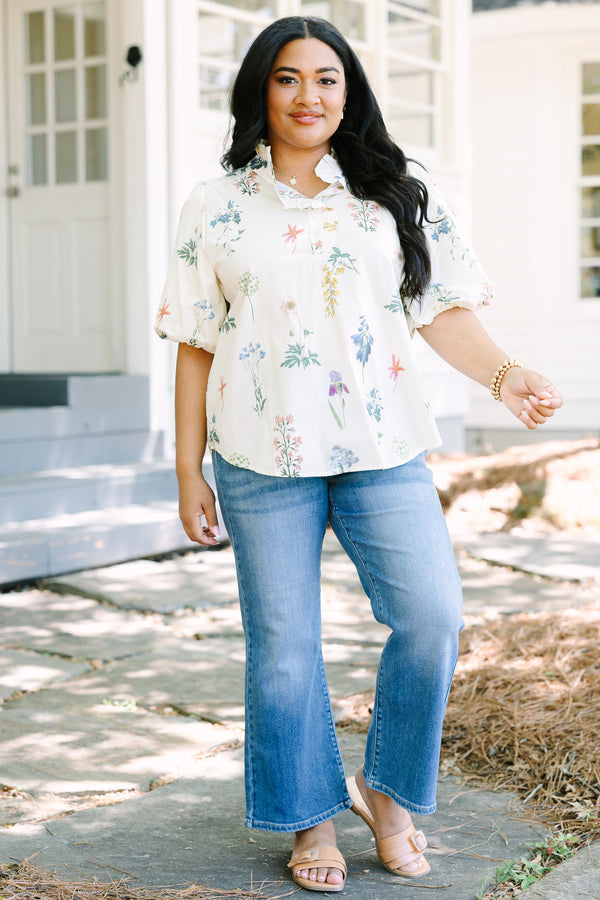 Ivory floral blouse with a relaxed fit, featuring a ruffled collar, short puff sleeves, and a lightweight woven fabric with a delicate multicolor botanical print.