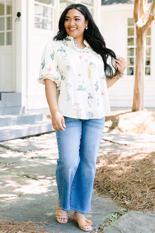 Ivory floral blouse with a relaxed fit, featuring a ruffled collar, short puff sleeves, and a lightweight woven fabric with a delicate multicolor botanical print.