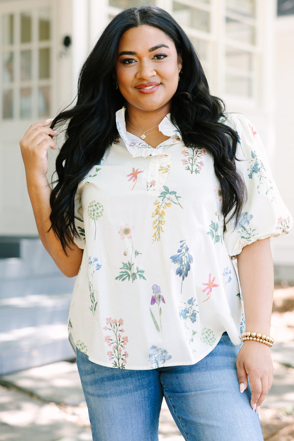 Ivory floral blouse with a relaxed fit, featuring a ruffled collar, short puff sleeves, and a lightweight woven fabric with a delicate multicolor botanical print.