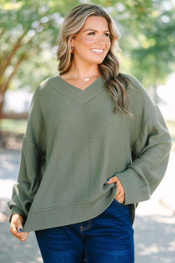 Plus Size olive green v-neck sweater with a relaxed fit, ribbed trim, and long drop-shoulder sleeves.
