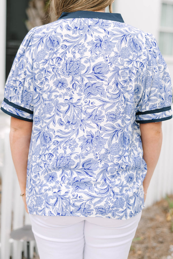 Chic Soul plus size clothing, white and light blue floral pattern puff sleeve top with navy blue trim along the bottom of the sleeves and outlining the v-neckline