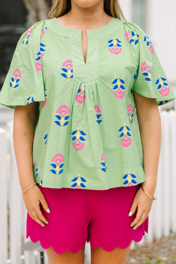 Chic Soul plus size clothing, green flutter short sleeve top with pink, blue, and yellow abstract floral pattern and v-neckline