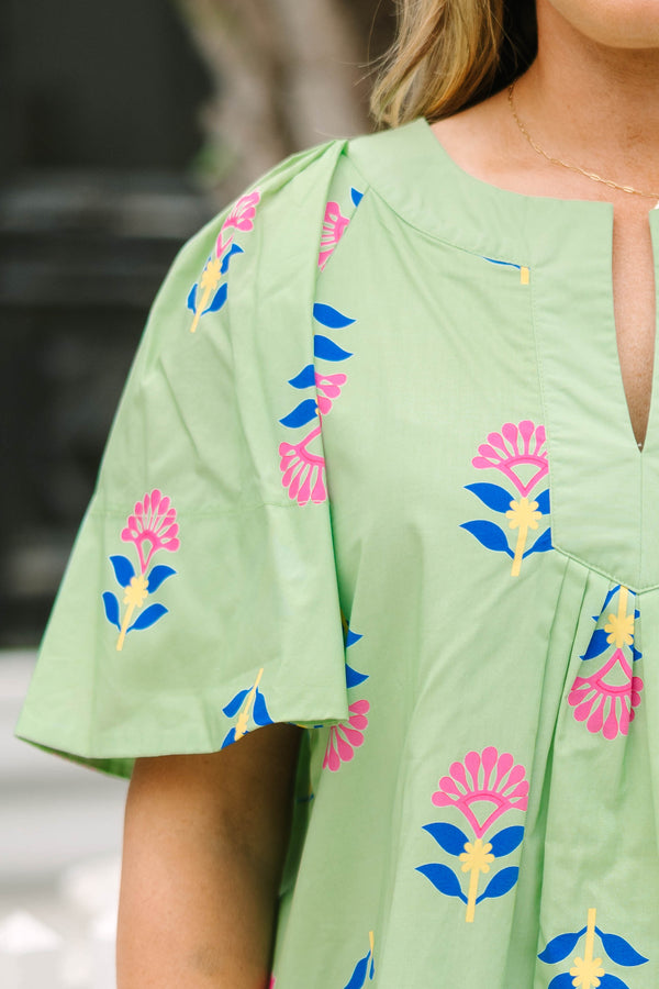 Chic Soul plus size clothing, green flutter short sleeve top with pink, blue, and yellow abstract floral pattern and v-neckline