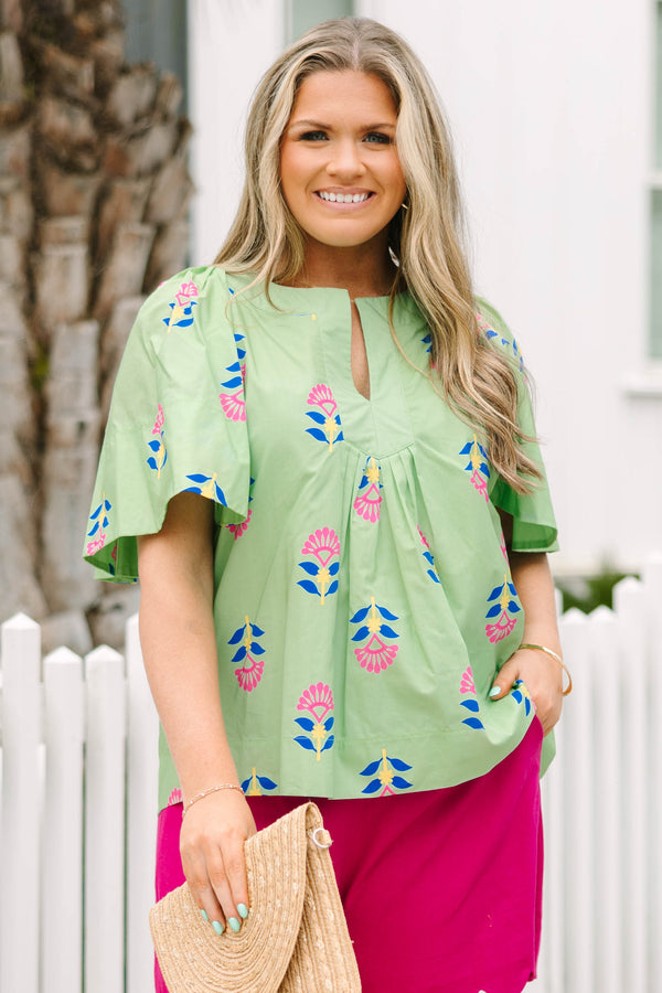 Chic Soul plus size clothing, green flutter short sleeve top with pink, blue, and yellow abstract floral pattern and v-neckline