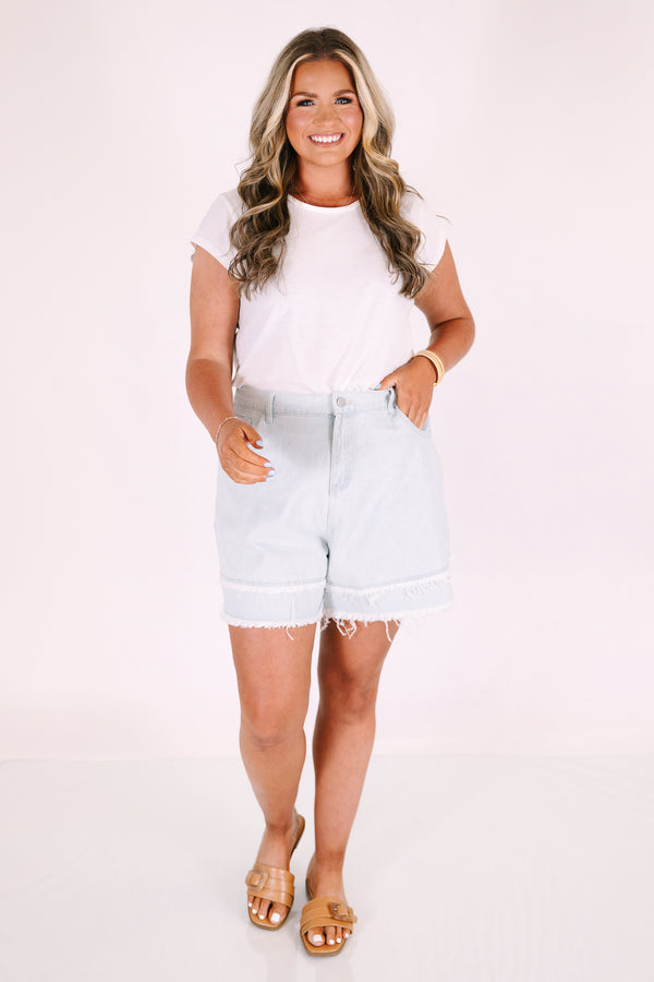 Plus Size light denim shorts with a relaxed fit and frayed illusion hem.