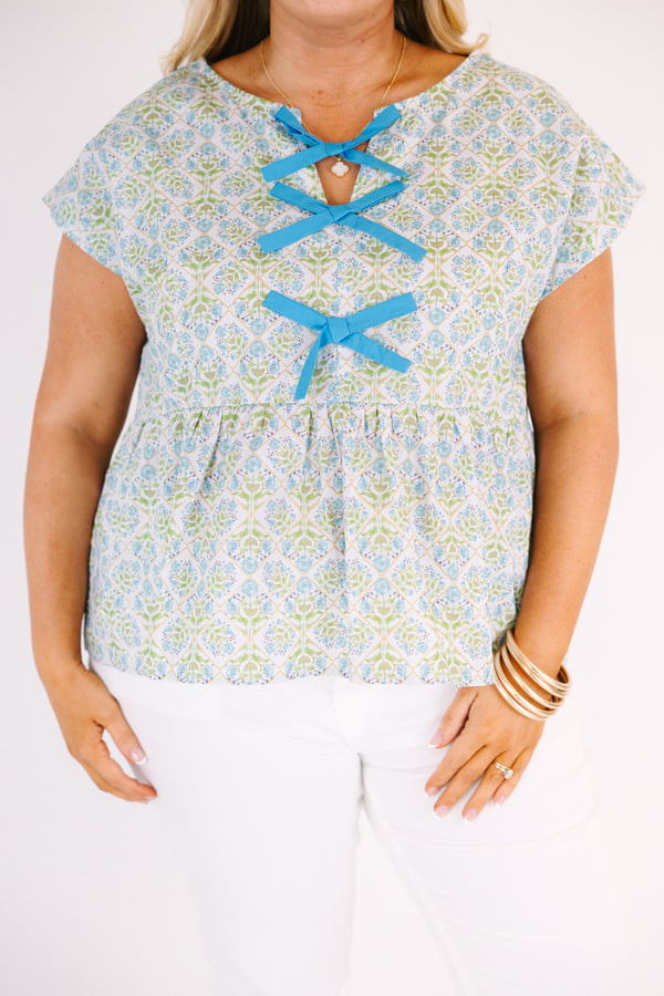 Chic Soul plus size clothing, teal short sleeve top with a floral block pattern and three blue bows going down the center of the bust 