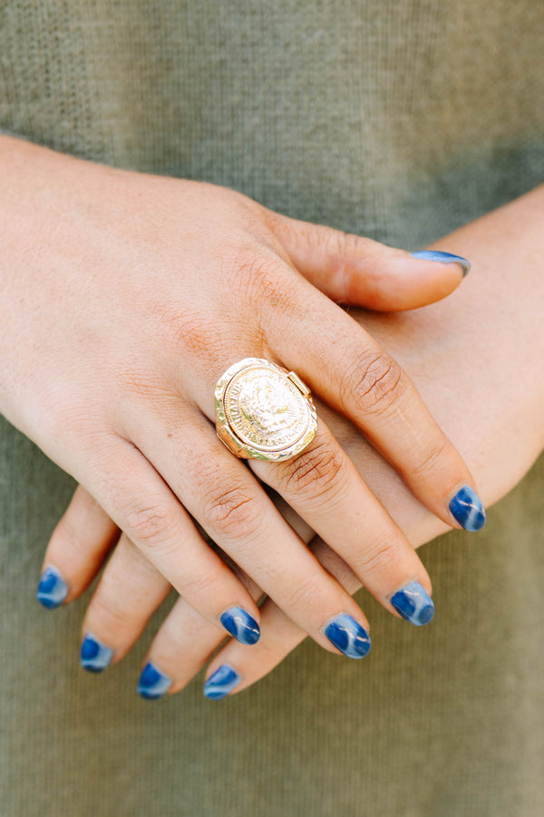 Close-up of a hand wearing the gold Saddle Creek coin ring