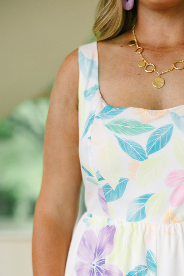 Plus Size floral wide-leg jumpsuit in white with pastel purple, pink, and blue tropical patterns.