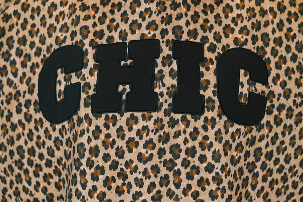 Plus Size brown leopard print mock neck pullover with black CHIC lettering and long sleeves.