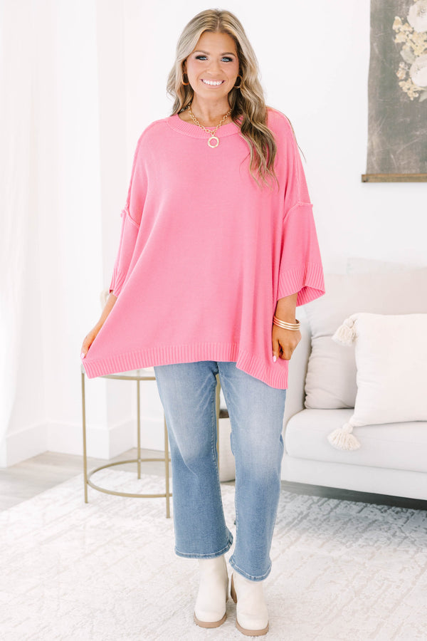 Bright pink sweater with a relaxed drop shoulder knit and exposed seams.