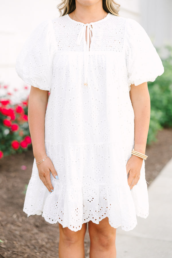 Plus Size white eyelet mini dress with puff sleeves, smocked bodice, and tassel tie neckline.