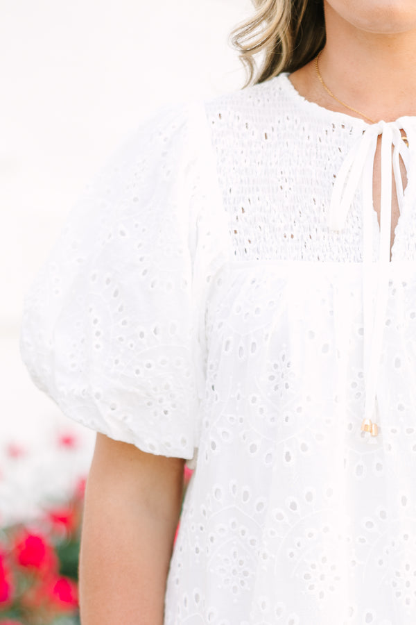 Plus Size white eyelet mini dress with puff sleeves, smocked bodice, and tassel tie neckline.