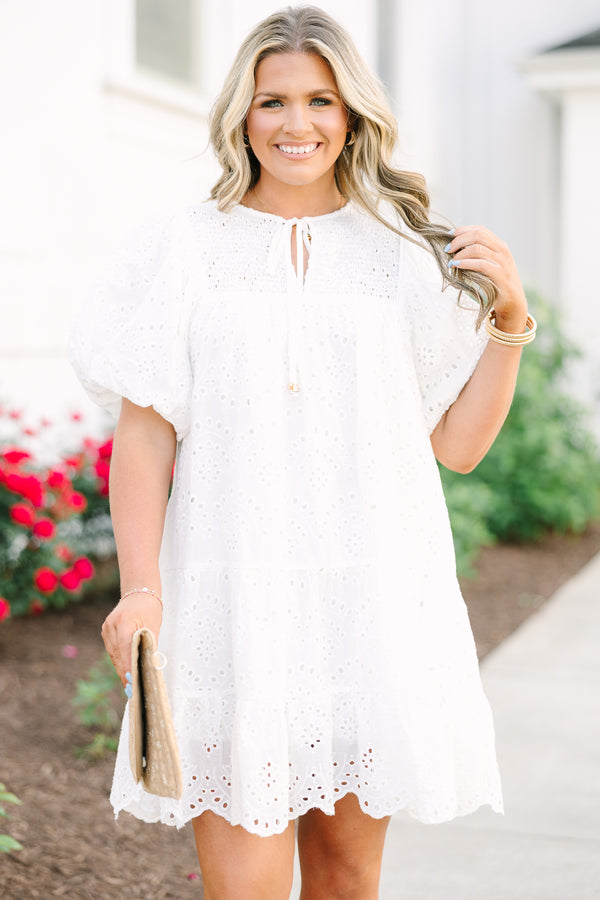 Plus Size white eyelet mini dress with puff sleeves, smocked bodice, and tassel tie neckline.