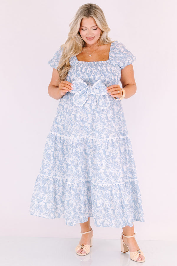 Chic Soul plus size clothing, blue and white toile print short puff sleeve square neck tiered maxi dress with bow tying at the waist and white scalloped trim around each tier and along the slides of the bow 
