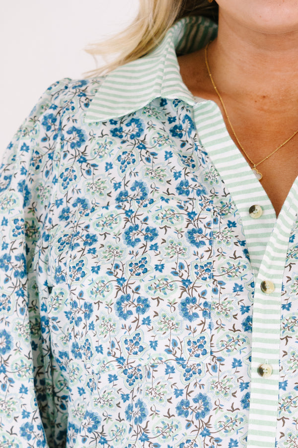 Chic Soul plus size clothing, blue button-up top with bubble sleeves and a floral pattern throughout as well as a green stripe detail going down the center of the shirt and on the collar 
