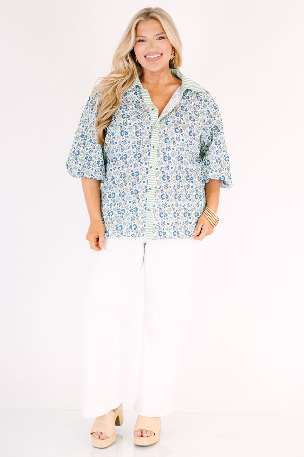 Chic Soul plus size clothing, blue button-up top with bubble sleeves and a floral pattern throughout as well as a green stripe detail going down the center of the shirt and on the collar 