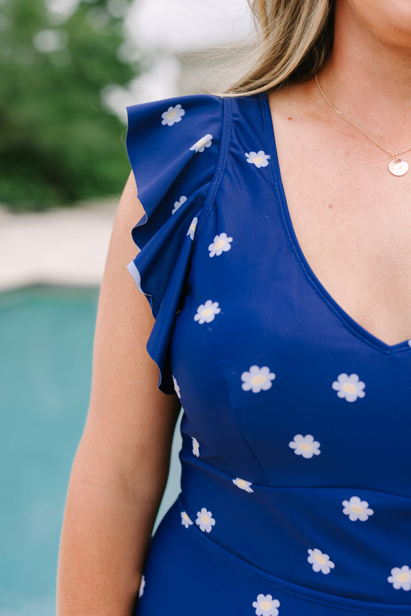 Plus Size navy blue one-piece swimsuit with a white daisy print and ruffled cap sleeves.