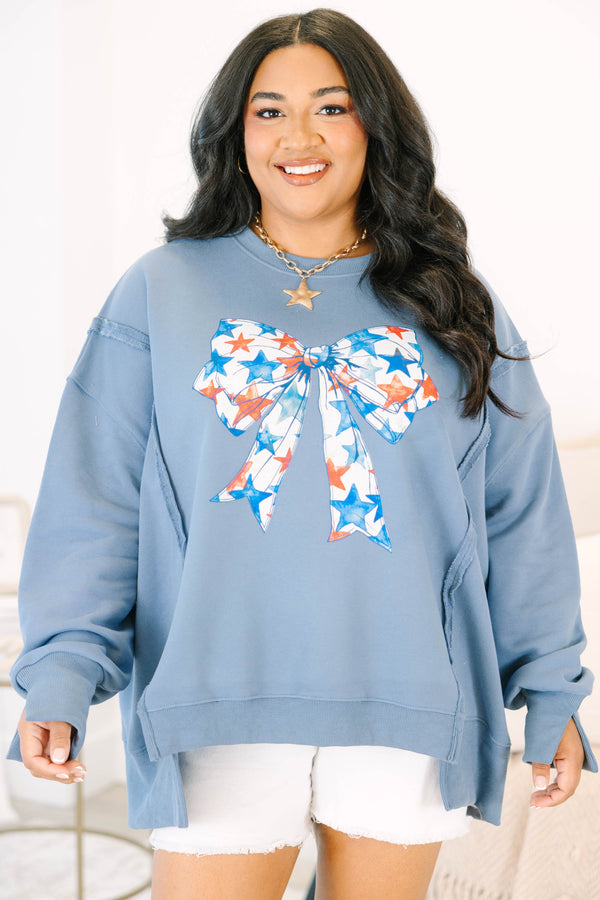 Plus Size denim blue crewneck sweatshirt with a large red and blue star-patterned bow graphic.