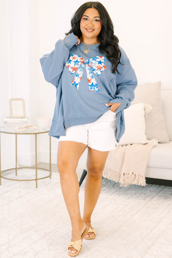 Plus Size denim blue crewneck sweatshirt with a large red and blue star-patterned bow graphic.