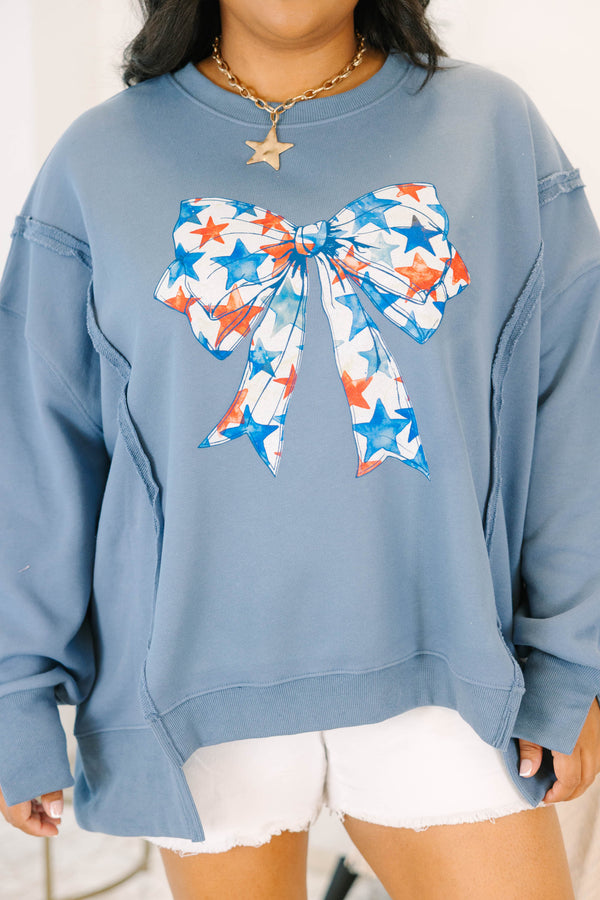 Plus Size denim blue crewneck sweatshirt with a large red and blue star-patterned bow graphic.