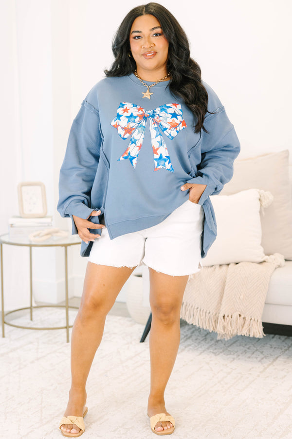 Plus Size denim blue crewneck sweatshirt with a large red and blue star-patterned bow graphic.
